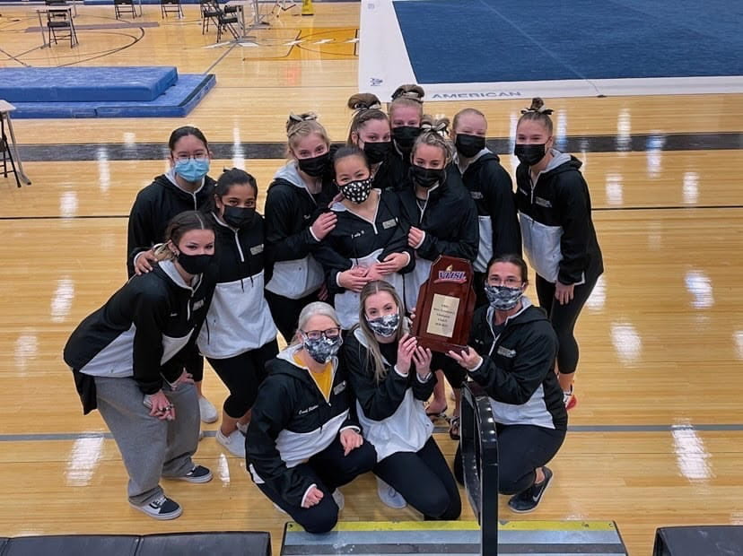 Photo provided by Emily Hyun. The Freedom gymnastics team takes their fourth consecutive state win and displays their trophy. 