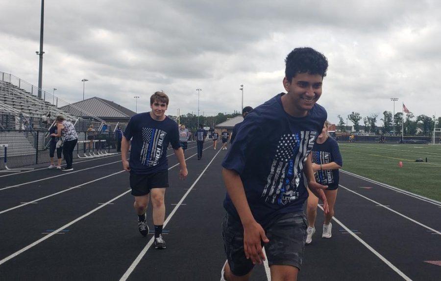 Freshman Kanav Sudi runs to the finish line during the Law Enforcement Torch Run for Special Olympics.