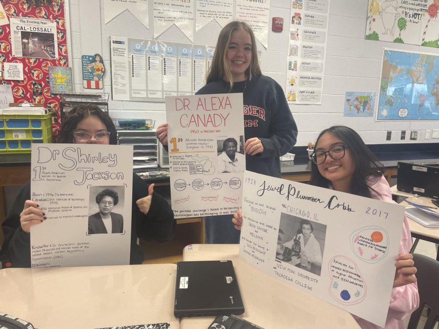 Emma Julander, Libby Donahoe, and Angeline Jackson holding up their posters.