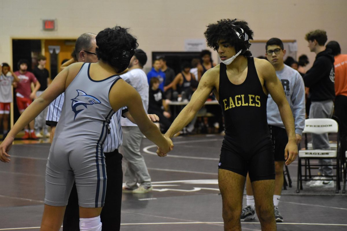 Shehab Salem shaking hands with an opponent before their match starts.