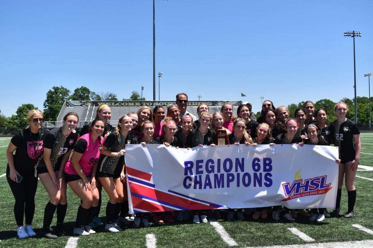 Freedom Girls Soccer Team holds the Regional 6B Champions poster after winning the Regional Championship game.