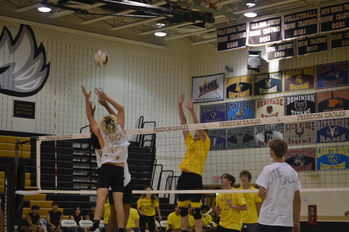 Juniors on the white team, Brayden McKeithen and Tarek Ashour, block junior on the gold team, Connor Hampton, during one of the Powderpuff volleyball games. 
