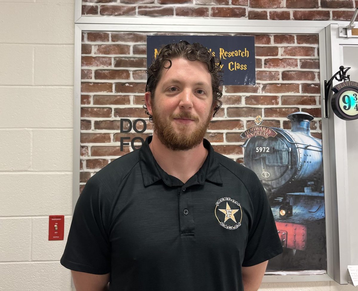 Mr. Yarbrough stands in front of his Harry Potter themed classroom bulletin board. 