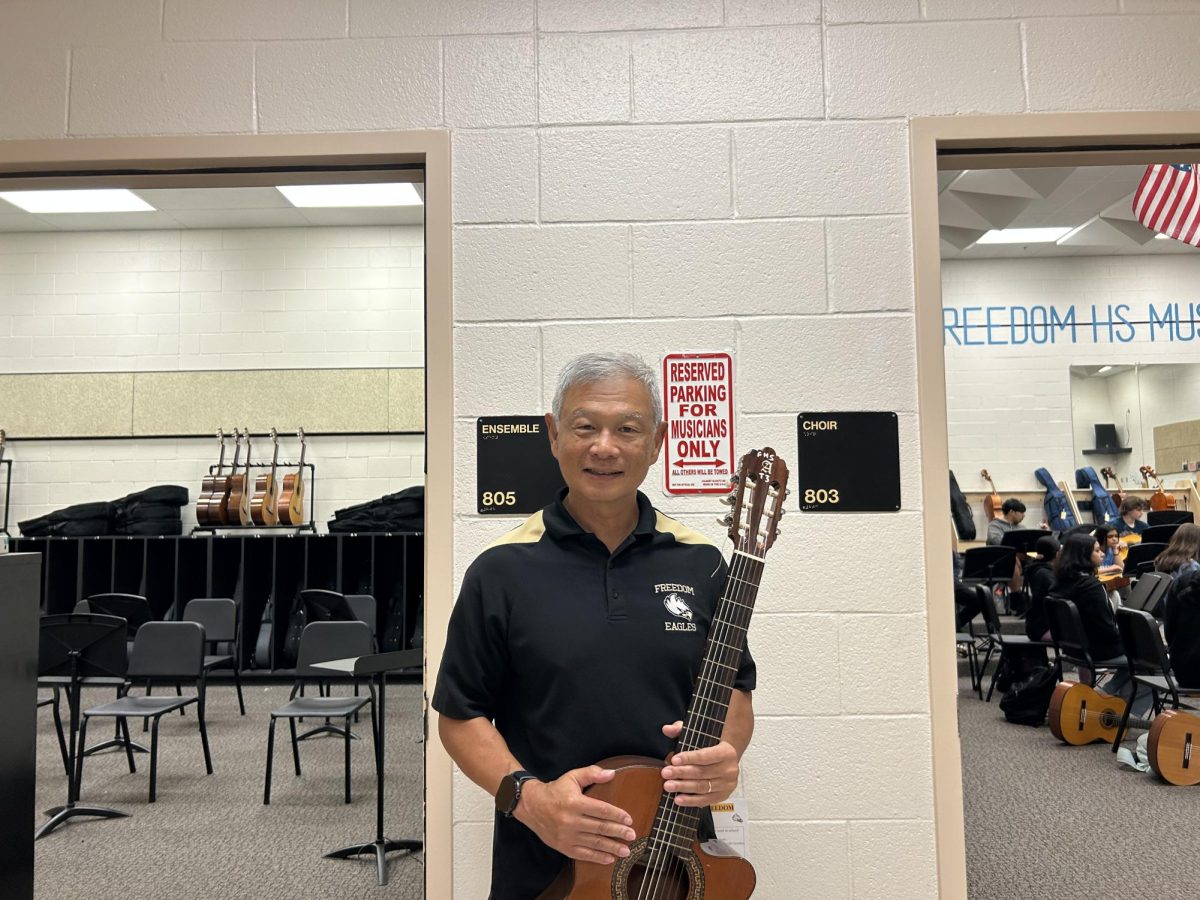Samuel Wong posing with his teaching guitar. 