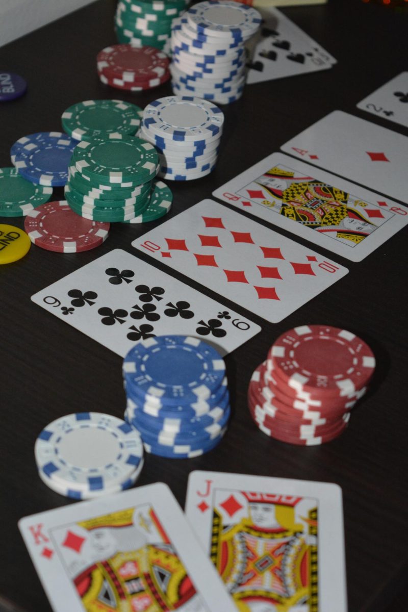 A game of poker where a player wins with a royal flush, collecting poker chips used as a form of currency. 
