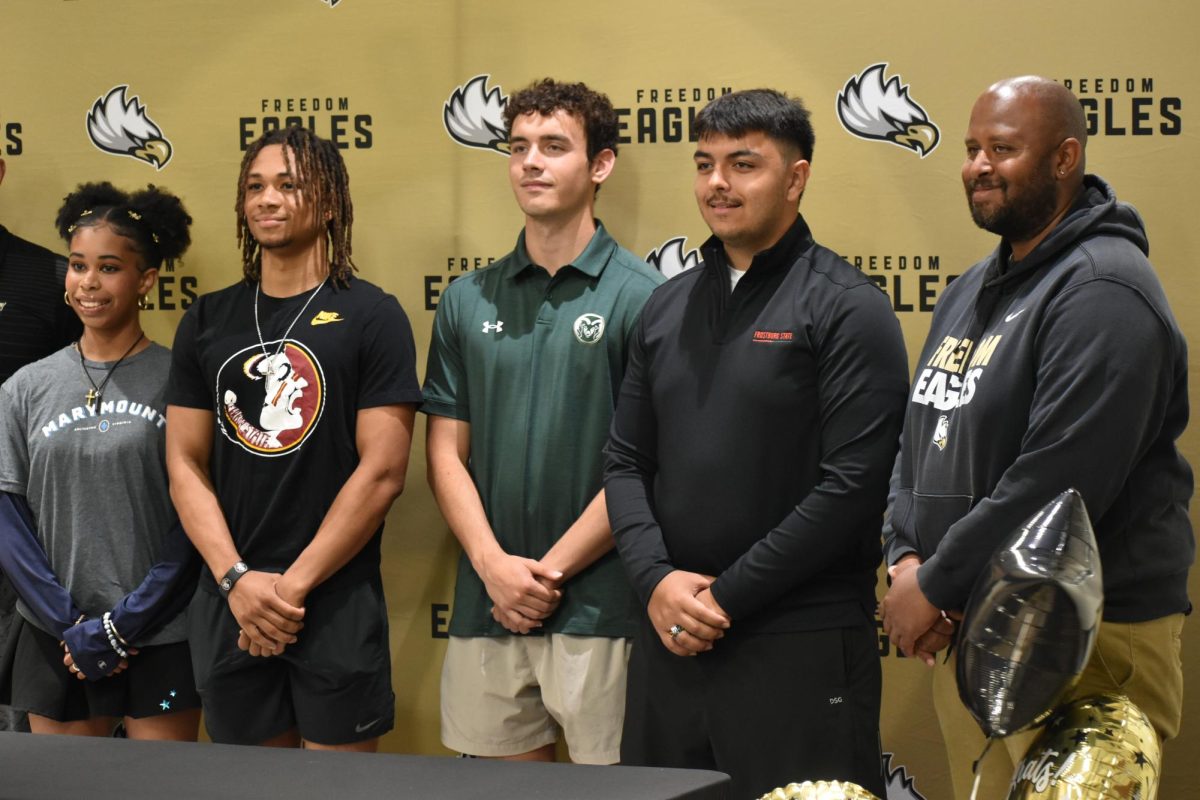 Seniors track athletes Kailen Kindall, Josh Johnson, Nate Danberg, Aram Bamyr and Coach Matthew Robinson pose for a picture during senior signing night. 